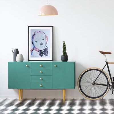 Plant and poster on green cabinet in retro living room interior with bicycle and copy space on the wall